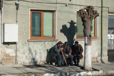 Chepelare - Bulgaristan - 9 Aralık 2019 - 3 yaşlı beyefendi ağaçların yanındaki bir bankta oturuyor..