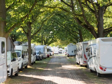 Karavanlar arka arkaya Dusseldorf 'taki Karavan Fuarı' nda ağaçların arasına park edilmiş. 