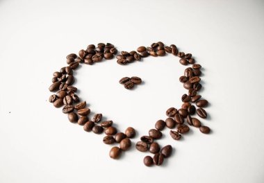 Beyaz arka planda kahve taneleri. Tanelerden yapılan farklı şekiller