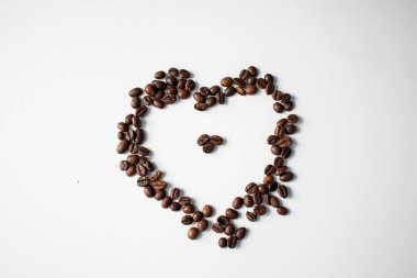 Beyaz arka planda kahve taneleri. Tanelerden yapılan farklı şekiller