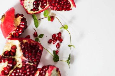 Beyaz arka planda nar meyvesi. Nane yaprakları kadar.