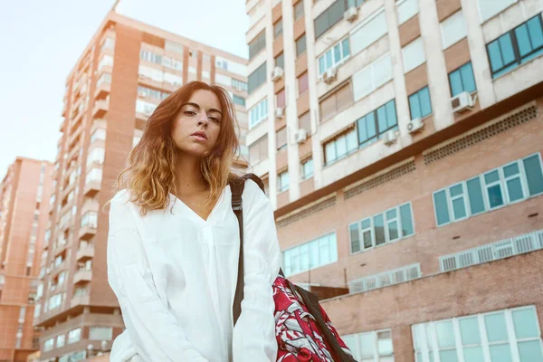 woman posing on street, on a background apartment block.