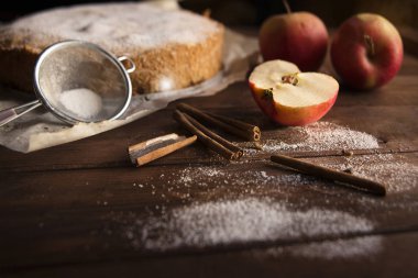 Elma, şeker ve tarçın ile ev yapımı kek ahşap arka plan üzerinde sopa.
