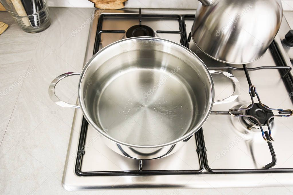 a metal pot on the stove with boiling water to cook spaghetti