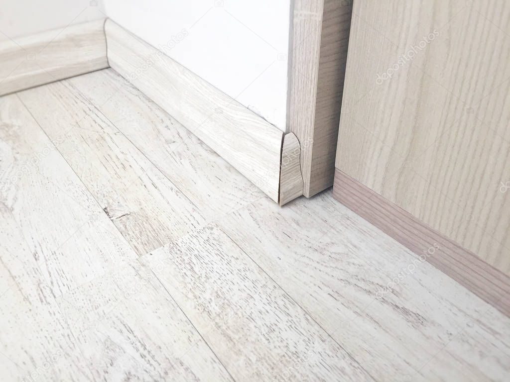 Wooden floor parquet with wooden baseboard. Interior design detail