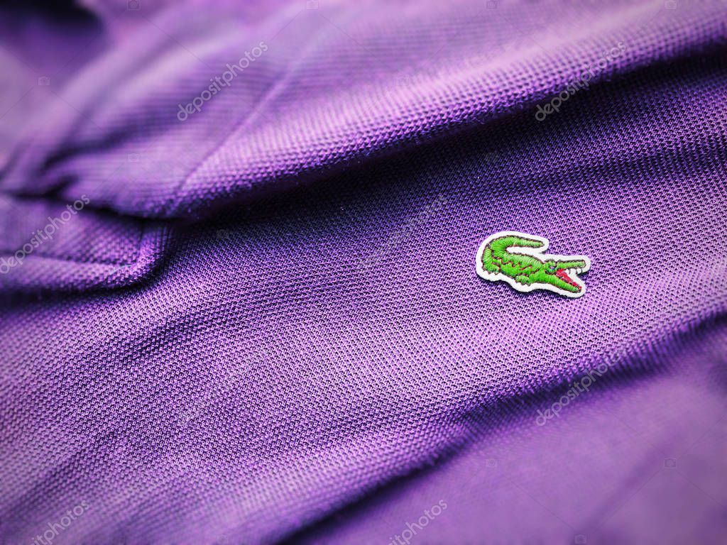 Rome, Italy, august 3rd 2018: close up view of a Lacoste purple polo shirt. Focus on the sewn crocodile
