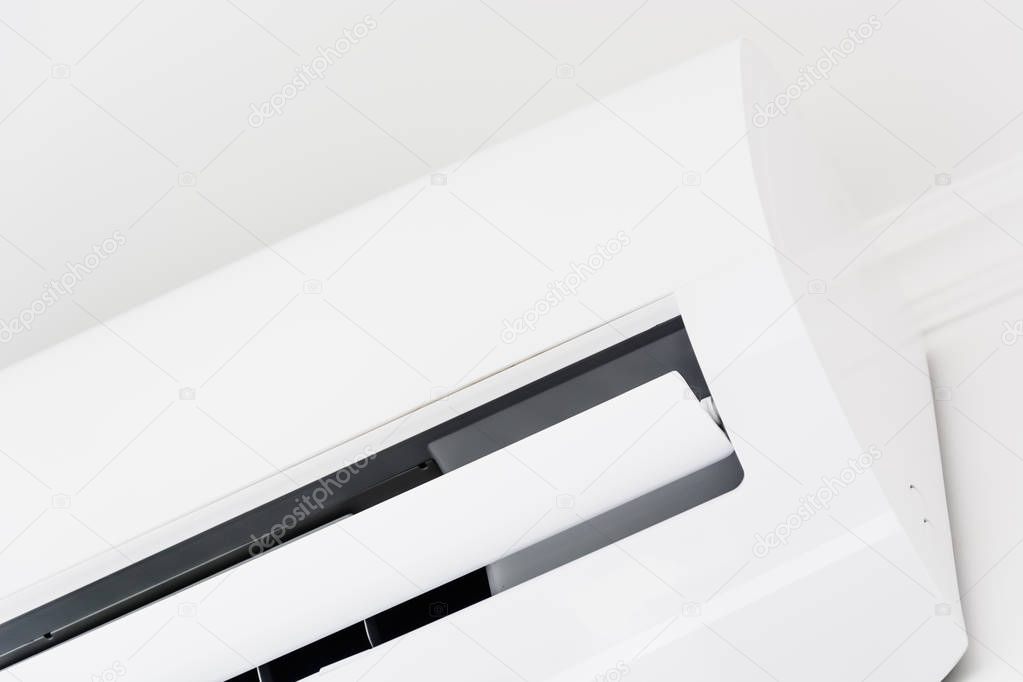 Close up of white air conditioner swing mounted on a white wall
