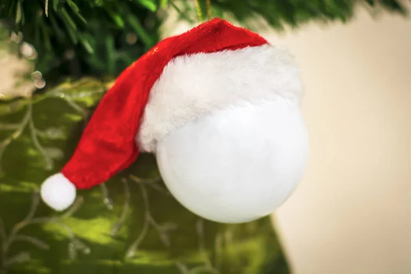 クリスマス ツリー サンタ クロースの赤い帽子のための装飾的な白いボールをぶら下げ — ストック写真