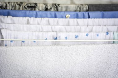 Farklı türde bir yaşında kuru giysiler solda asılı