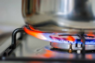 Mutfak ocağından yanan mavi alev. Gaz ve ateş. Yemek pişirme konsepti. İç mekandan ateş edilmiş.
