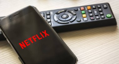 Roma, İtalya, 12 Ocak 2019; arka planda bir Tv Uzaktan kumanda ile Netflix logo ekranlı cep telefonu