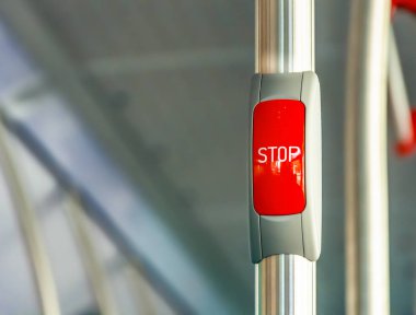 Red stop button on the metal handrail of a bus clipart