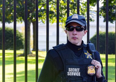Güneş gözlüğü takan genç bir subay ve Washington D.C.'de Beyaz Saray'ı koruyan Amerikan Gizli Servisi üniforması..