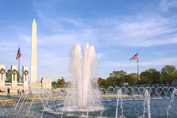 Salpicaduras de agua de la fuente en el monumento a la Segunda Guerra Mundial con el Monumento a Washington en el fondo en el National Mall en Washington D.C. . — Foto de Stock