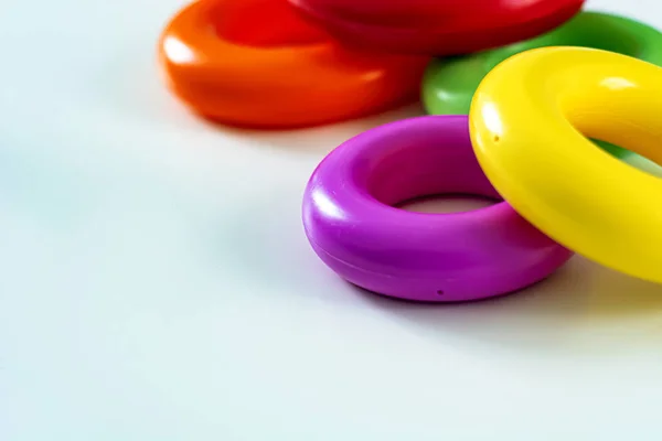 Colorful plastic rings on a white background to be stacked in a tower.