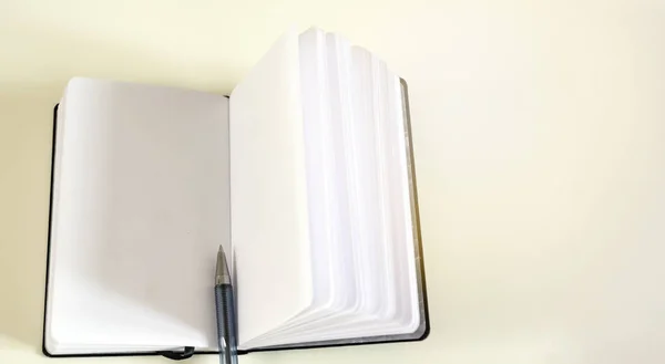 Uma caneta esferográfica no meio de um caderno aberto — Fotografia de Stock