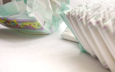 close-up view of a group of folded white diapers ready to be used. Health care of the newborn clipart