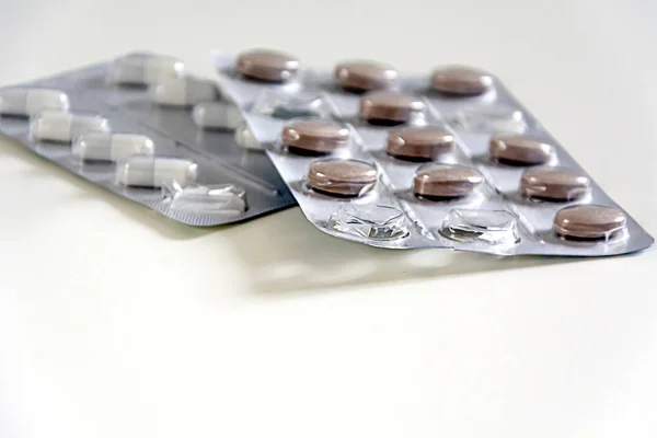Медичні таблетки, упаковані в блискучі пластикові пухирі. Блістер з деякими використаними таблетками — стокове фото