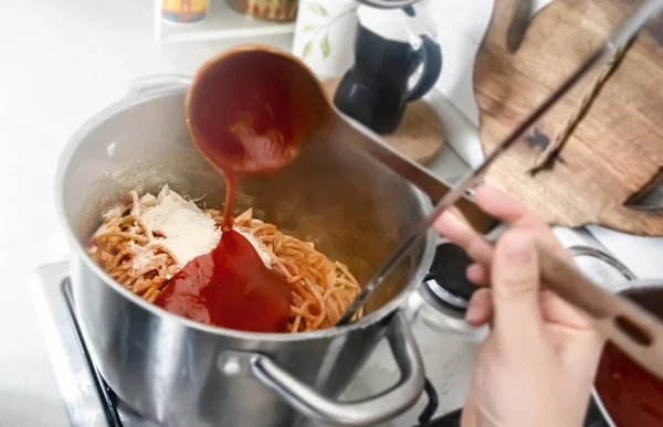 鉄板鍋でトマトソースを注ぐことで 焼きたてのスパゲティをたっぷりと味付け イタリア家庭料理 — ストック写真