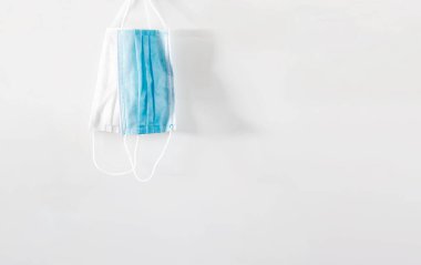 Beyaz arka planda bir çift cerrahi maske var. Kişisel bakım ve virüs önleme