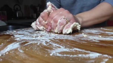 Tahtada un yoğuran bir kadın. Un bazlı yemeklerin hazırlanması. Ekmek, pizza ve kek hazırlamak için hamur. Ev yapımı yemek.