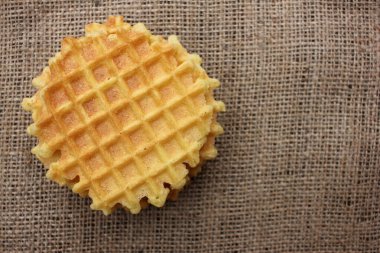 Çuval bezi desenli arka planda waffle 'ın yakın çekimi. Üst görünüm, alanı kopyala