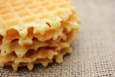 Çuval bezi desenli arka planda waffle 'ın yakın çekimi. Üst görünüm, alanı kopyala