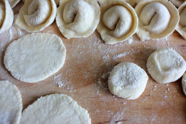 Bir sıra ev yapımı hamur köftesini etle kapat. Evde pişirme süreci. Üst görünüm, seçici odak