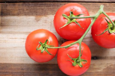 Kırsal ahşap masadaki sarmaşıkta taze domatesler. Üst Manzara. Boşluğu kopyala