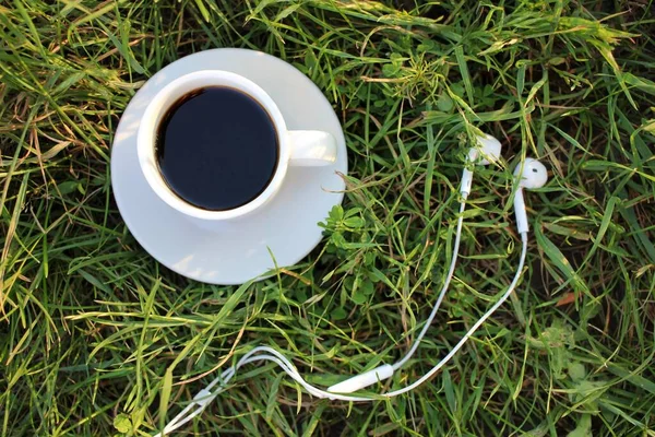 Белая Чашка Кофе Наушники Зеленой Траве Вид Сверху Принято Летний — стоковое фото