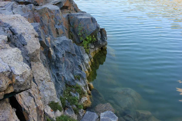 花岗岩岩石在水中的特写 天然石墙背景 有选择的重点 旧的浸水采石场 — 图库照片