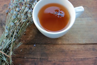Yukarıdan ahşap masada lavanta çiçekli bitki çayı..