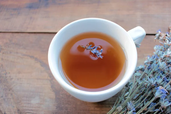 Yukarıdan ahşap masada lavanta çiçekli bitki çayı..