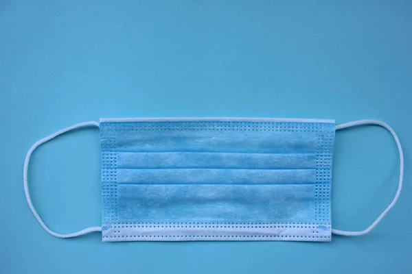 コピースペース付きの青の背景に使い捨て医療面マスク パンデミック保護顔カバー — ストック写真