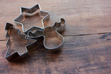 Noel ağacı, yıldız ve geyik şekilli kurabiye kesiciler ahşap bir masada. Noel arkaplanı. Üst görünüm, alanı kopyala