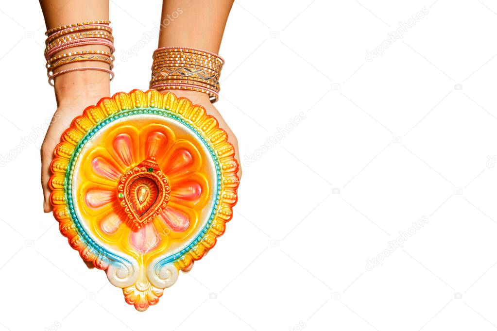 Happy Diwali - Woman hands with henna holding lit candle isolated on white background. Hindu festival of lights celebration. Copy space for text.