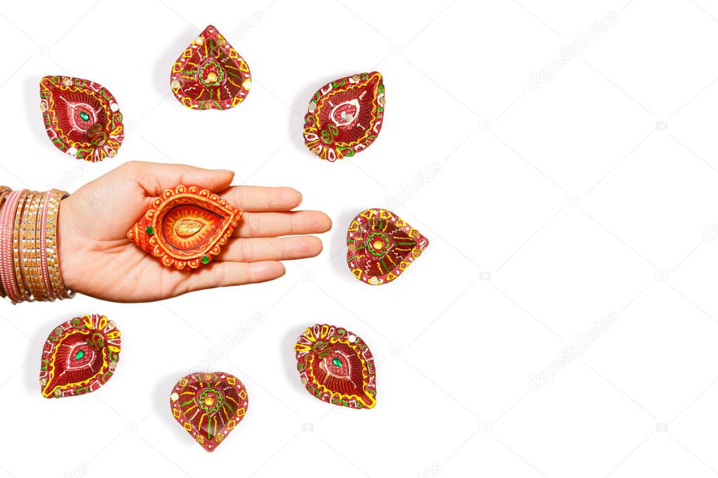 Happy Diwali - Woman hands with henna holding lit candle isolated on white background. Hindu festival of lights celebration. Copy space for text.