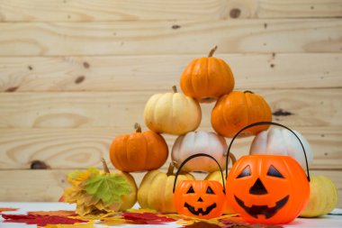 Ahşap arka planda akçaağaç yaprakları olan balkabağını kapat. Mutlu cadılar bayramı kavramları.