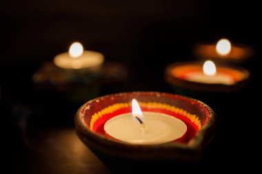 Mutlu Diwaliler - Dipavali sırasında Clay Diya lambaları yandı, Hindu ışık festivali kutlaması. Koyu arka planda renkli geleneksel gaz lambası diya. Metin için alanı kopyala.