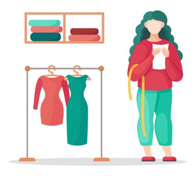 Ölçüm bandı ve notları olan tasarımcı elbise ve dikiş dükkanı konseptiyle tezgahın yanında duruyor.