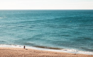 İnsanlar yaz boyunca İspanya 'da güzel deniz kıyısında güneşli sahilde yürüyorlar..
