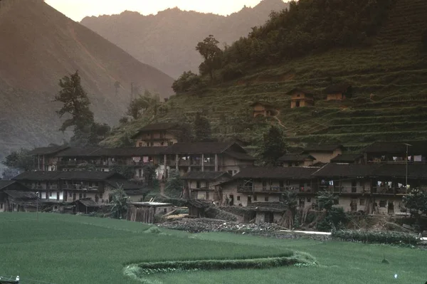 前の棚田と丘の中腹に泥レンガ造りの家の中国の村 — ストック写真