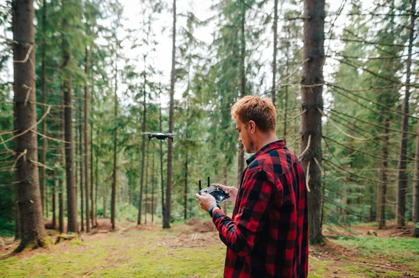 Joven Guapo Controla Dron Bosque Mirando Atentamente Mando Distancia Vuelos — Foto de Stock