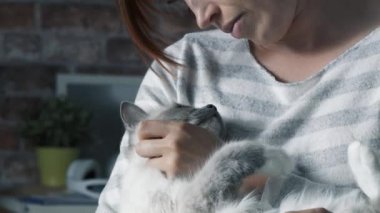 Güzel bir kedi onun kollarında tutan kadın