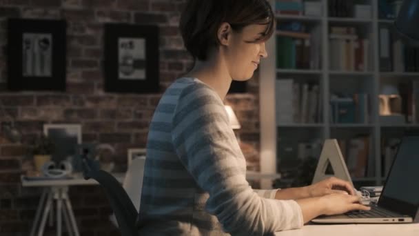 Жінка спілкується зі своїм ноутбуком вдома — стокове відео