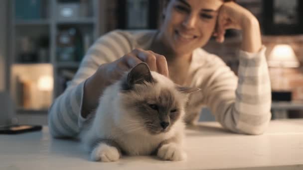 Mujer sonriente acariciando a su gato en casa — Vídeos de Stock