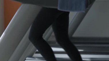 Kadının koşu bandı üzerinde bir kardiyo egzersiz yapması