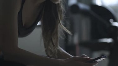 Spor salonunda molası ve telefonunu kullanarak kadın