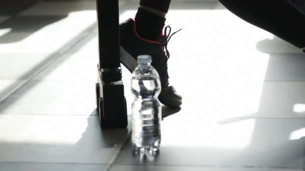 Mujer en el gimnasio tomando un descanso y bebiendo agua — Vídeo de stock