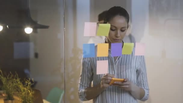 Young businesswoman writing a sticky note — Stock Video
